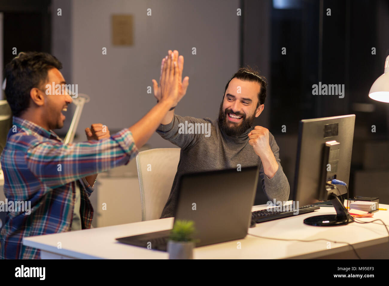 creative team making high five at night office Stock Photo - Alamy