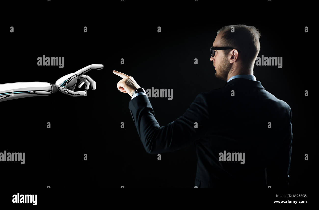 robot and human hand flash light over black Stock Photo