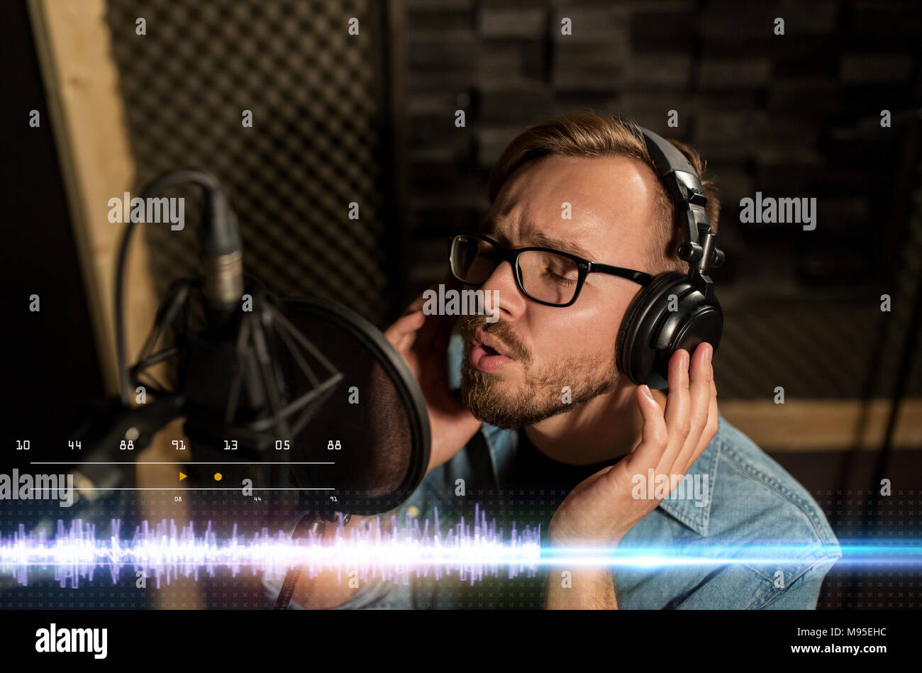 man with headphones singing at recording studio Stock Photo
