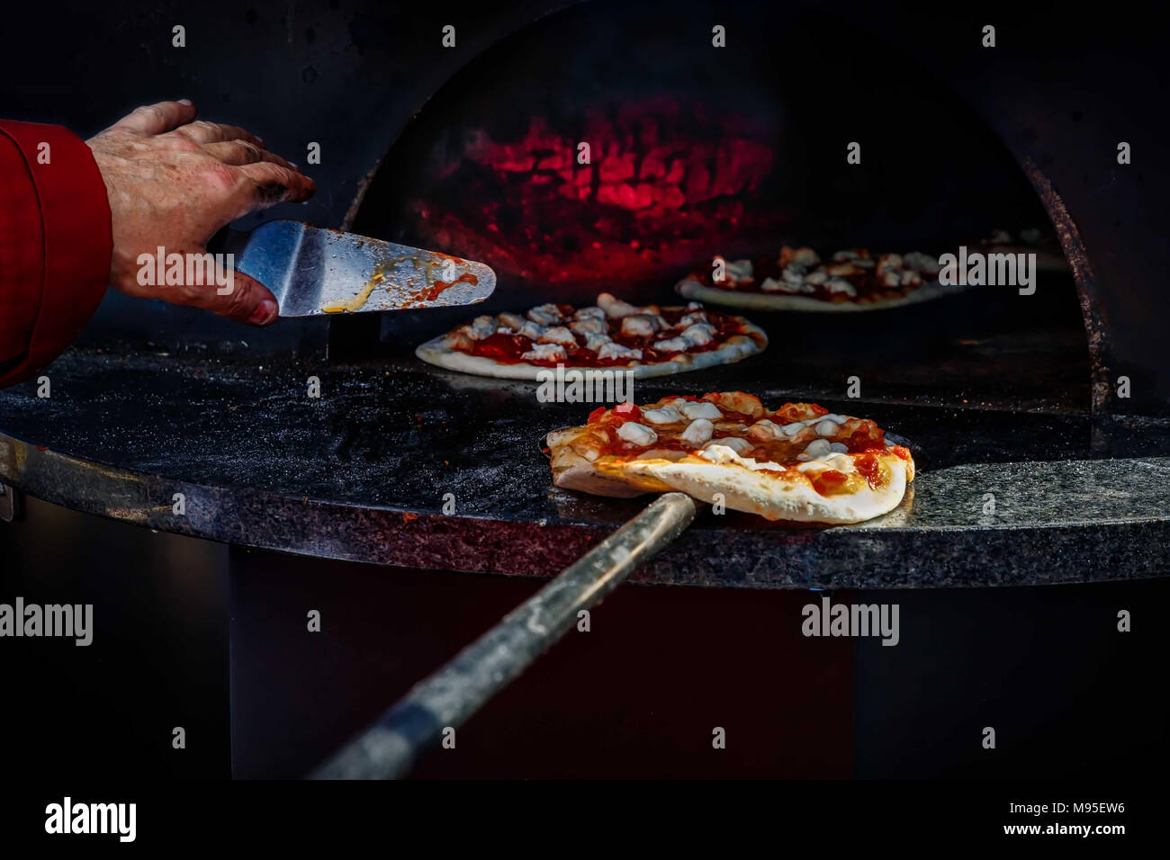 A master of the pizza oven working his craft. Stock Photo