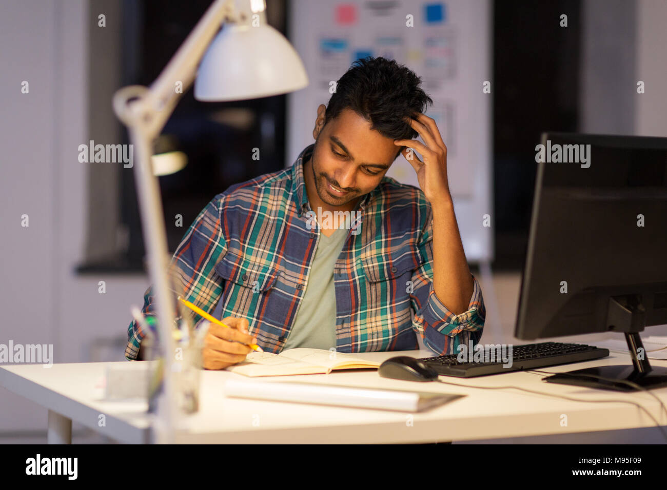 creative man with notebook working at night office Stock Photo