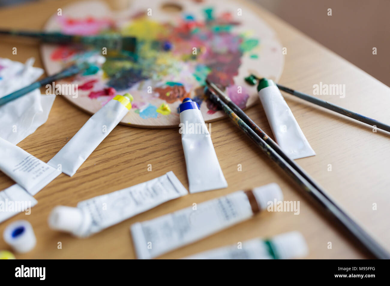 Art brushes, oil paint tubes, artist palette on wooden table Stock Photo by  ©ChamilleWhite 19857057