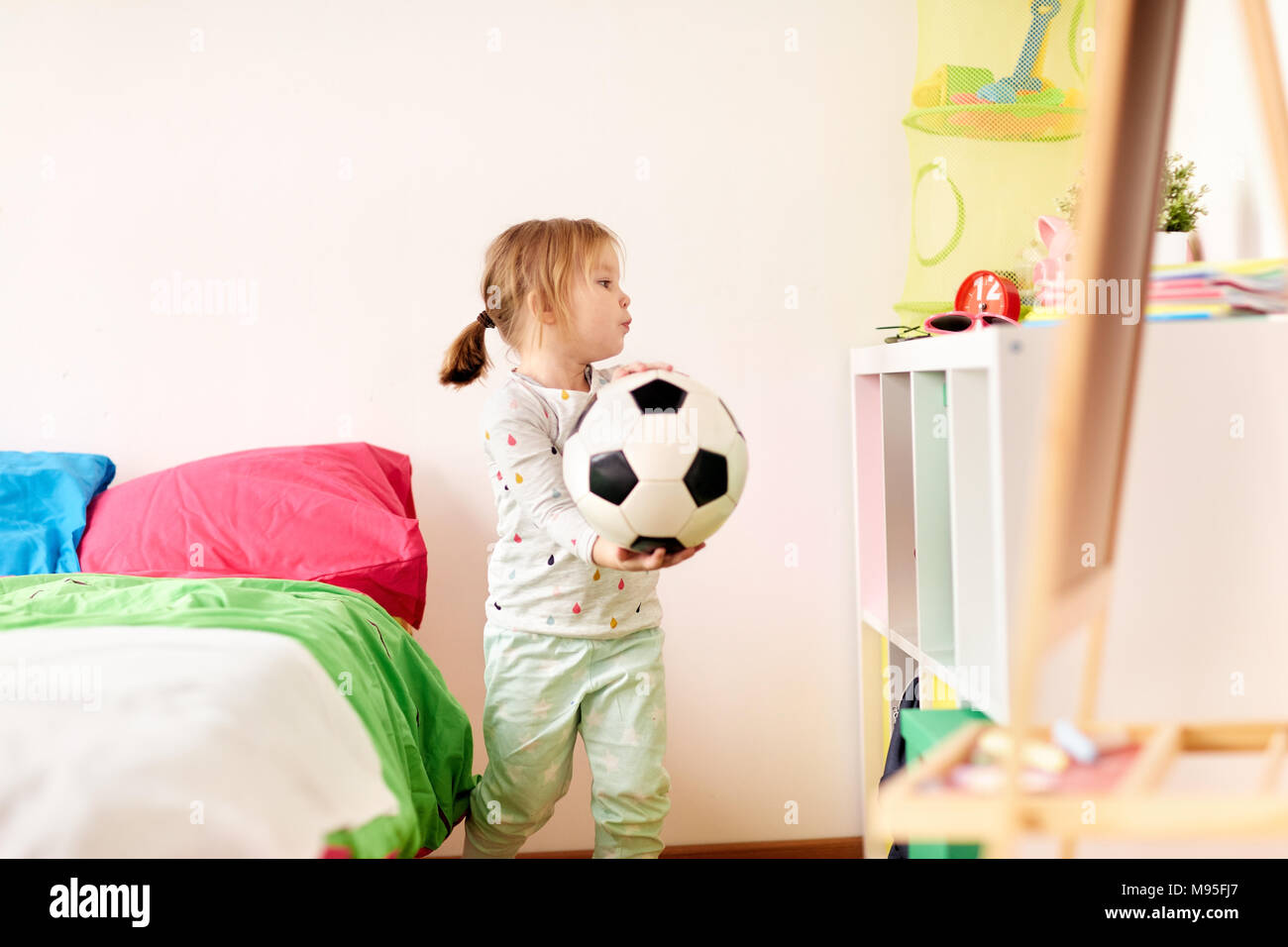 happy little girl with socker ball at home Stock Photo