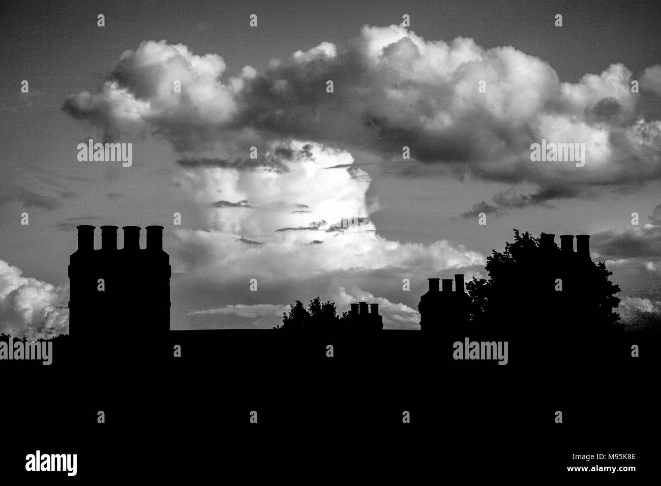 A fantastic cloud formation on the horizon behind the silhouetted form of chimney stacks, South London. UK Stock Photo