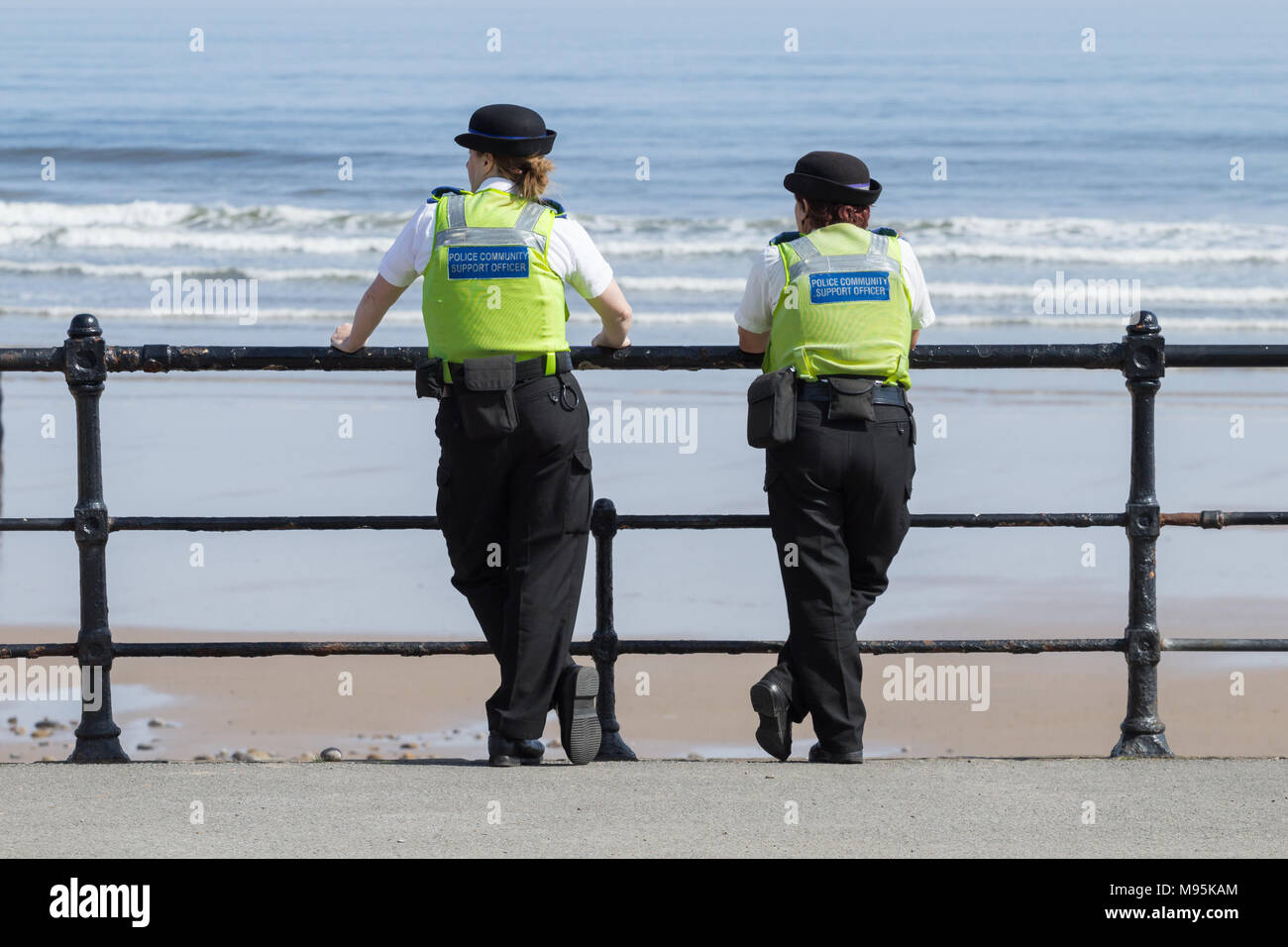 Female Police community support officers overlooking beach on a sunny day Stock Photo