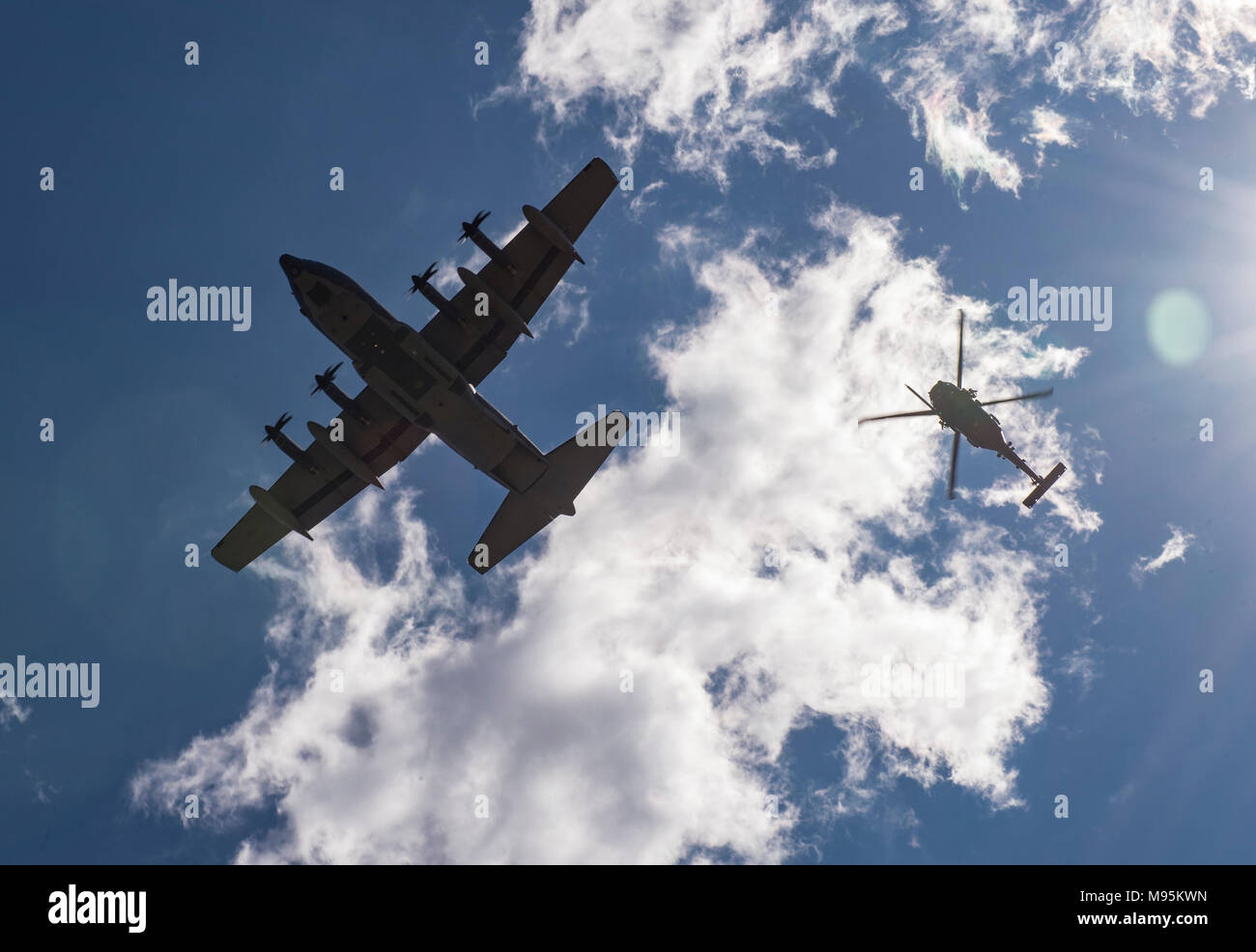 An HC-130J Combat King II and an HH-60G Pave Hawk fly over a formation of Airmen following a memorial service in honor of Capt. Mark Weber, March 21, 2018, at Moody Air Force Base, Ga. Weber, a 38th Rescue Squadron combat rescue officer and Texas native, was killed in an HH-60G Pave Hawk crash in Anbar Province, Iraq, March 15. During the ceremony, Weber was posthumously awarded a Meritorious Service Medal and the Air Force Commendation Medal. (U.S. Air Force photo by Andrea Jenkins) Stock Photo