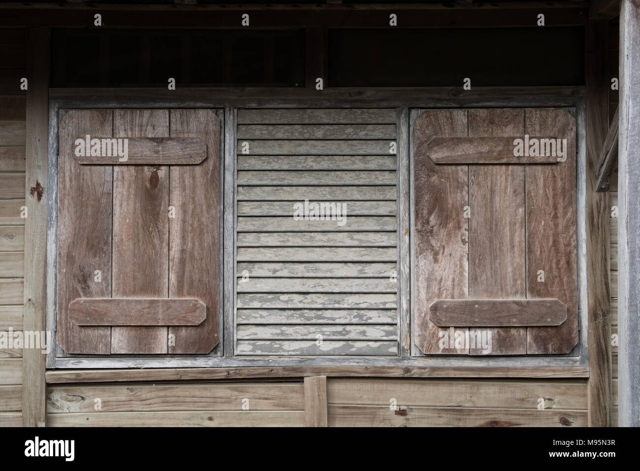 window with closed shutters - wooden building exterior with closed shutter - Stock Photo