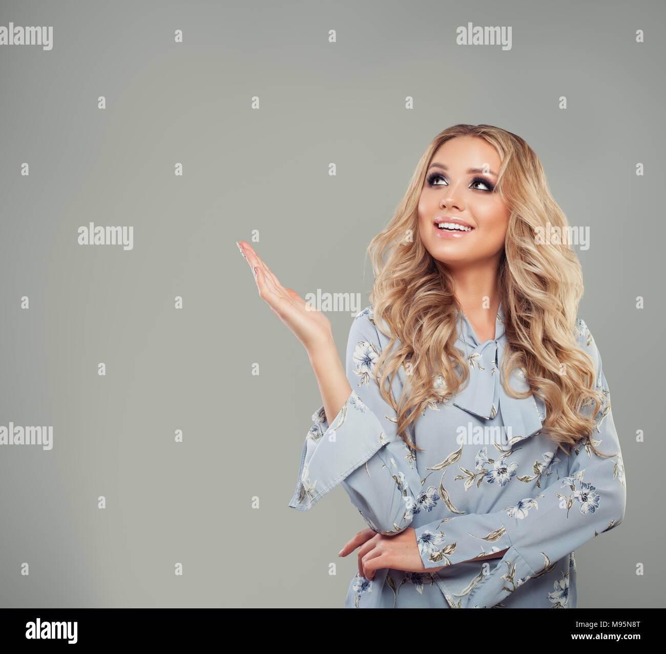 Cute Woman Fashion Model Pointing her Hand on Gray Background Stock Photo