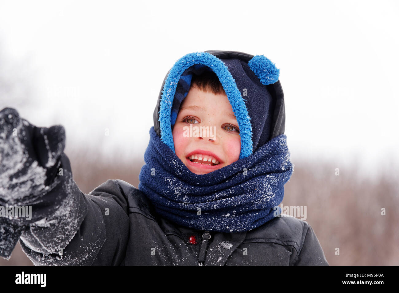 Portrait of young boy (5 yrs old) wearing winter hat and scarf Stock Photo