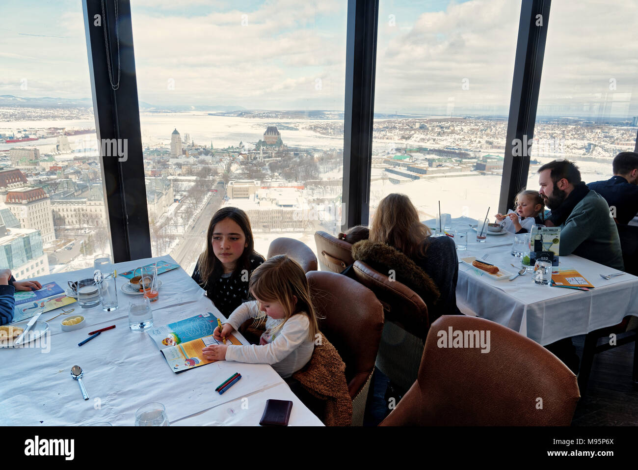 Families dining in the Ciel! rotating restaurant in Quebec City, with iews across the frozen St Lawrence and the Chateau Frontenac Stock Photo