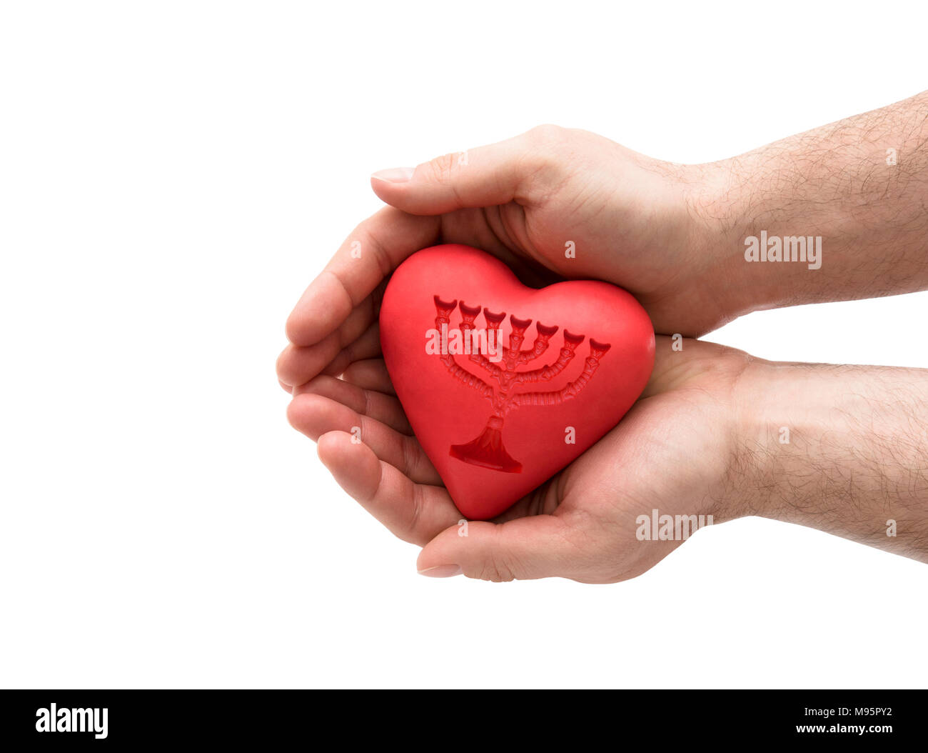 Red heart with imprinted menorah in man's hands. Stock Photo