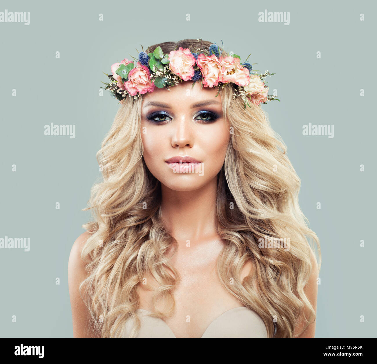 Perfect Young Woman with Long Wavy Hair and Flowers. Blonde Beauty