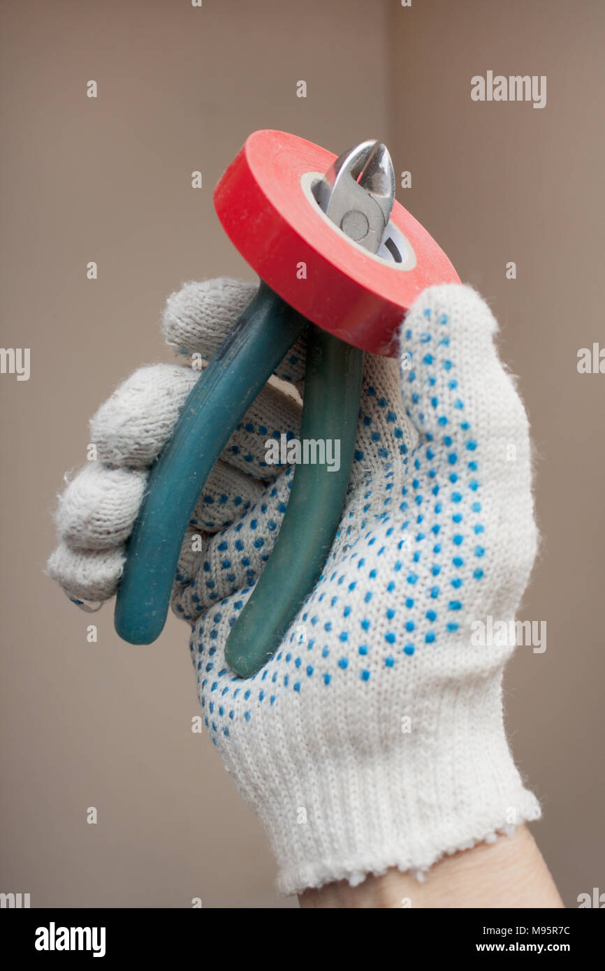 Hand holding the working cutters and electrical tape Stock Photo - Alamy