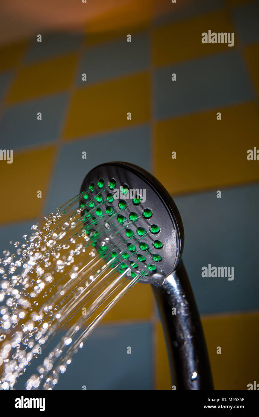 A shower head spraying a full flow of water in a shower Stock Photo Alamy