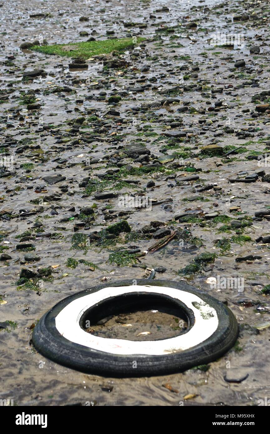 Discarded whitewall car tire in the sand of Bottle Beach, the western shore of Dead Horse Bay, Brooklyn, New York, USA. Stock Photo