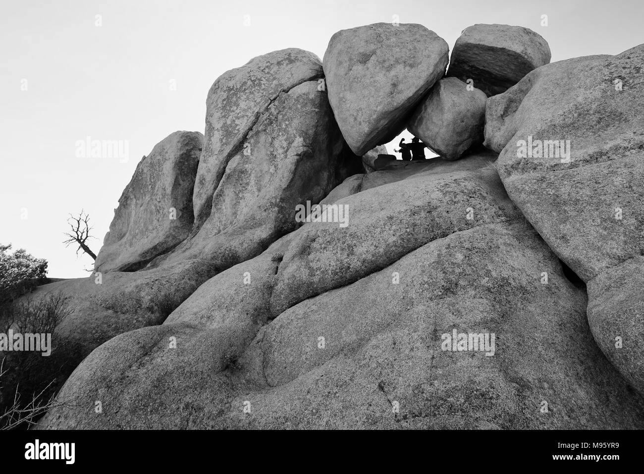 Two climbers are Silhouetted in the Rocks at Joshua Tree National Park Stock Photo