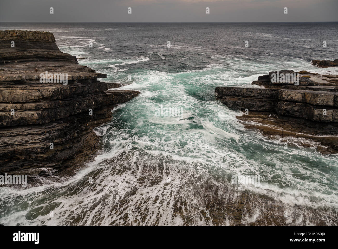 Waves crashing against rocks at Loop Head Bridges of Ross on Ireland's Atlantic coast in County Clare Stock Photo