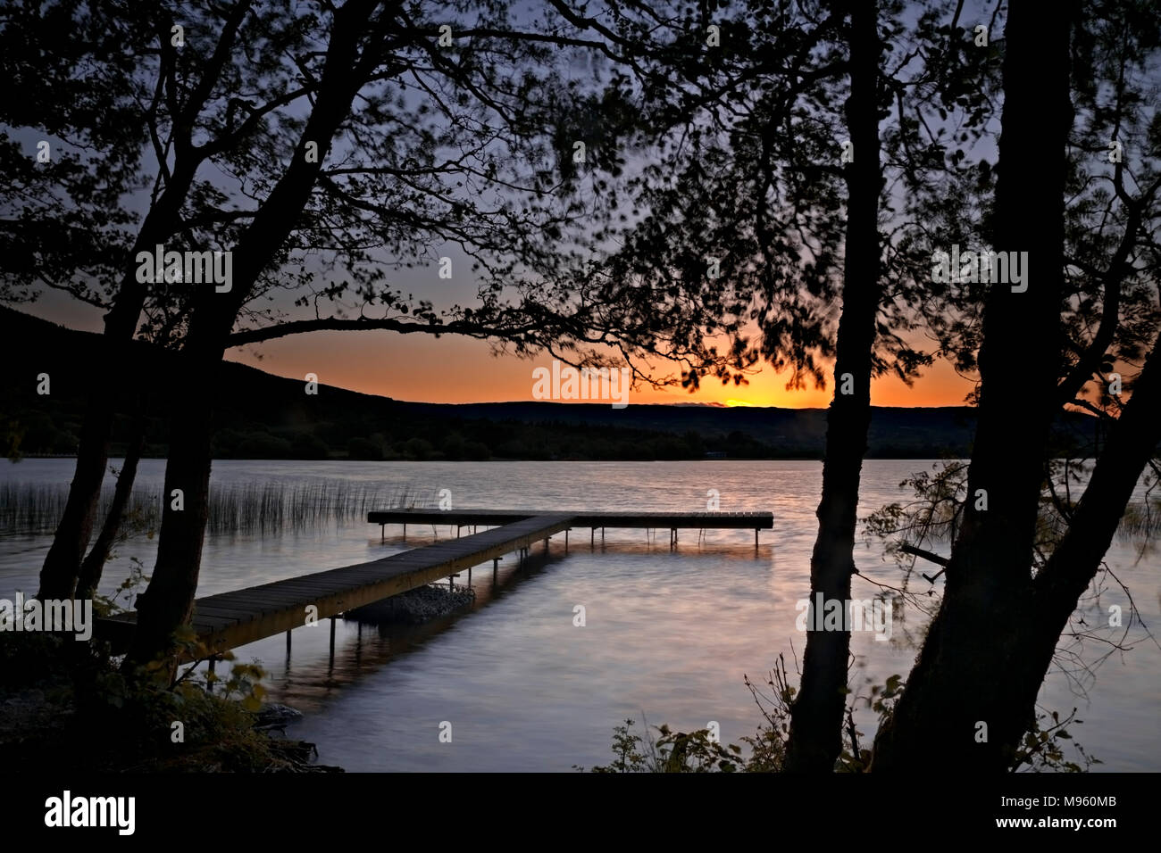 Wooden jetty on the shore of Lough Derg, County Clare, Ireland at sunset Stock Photo