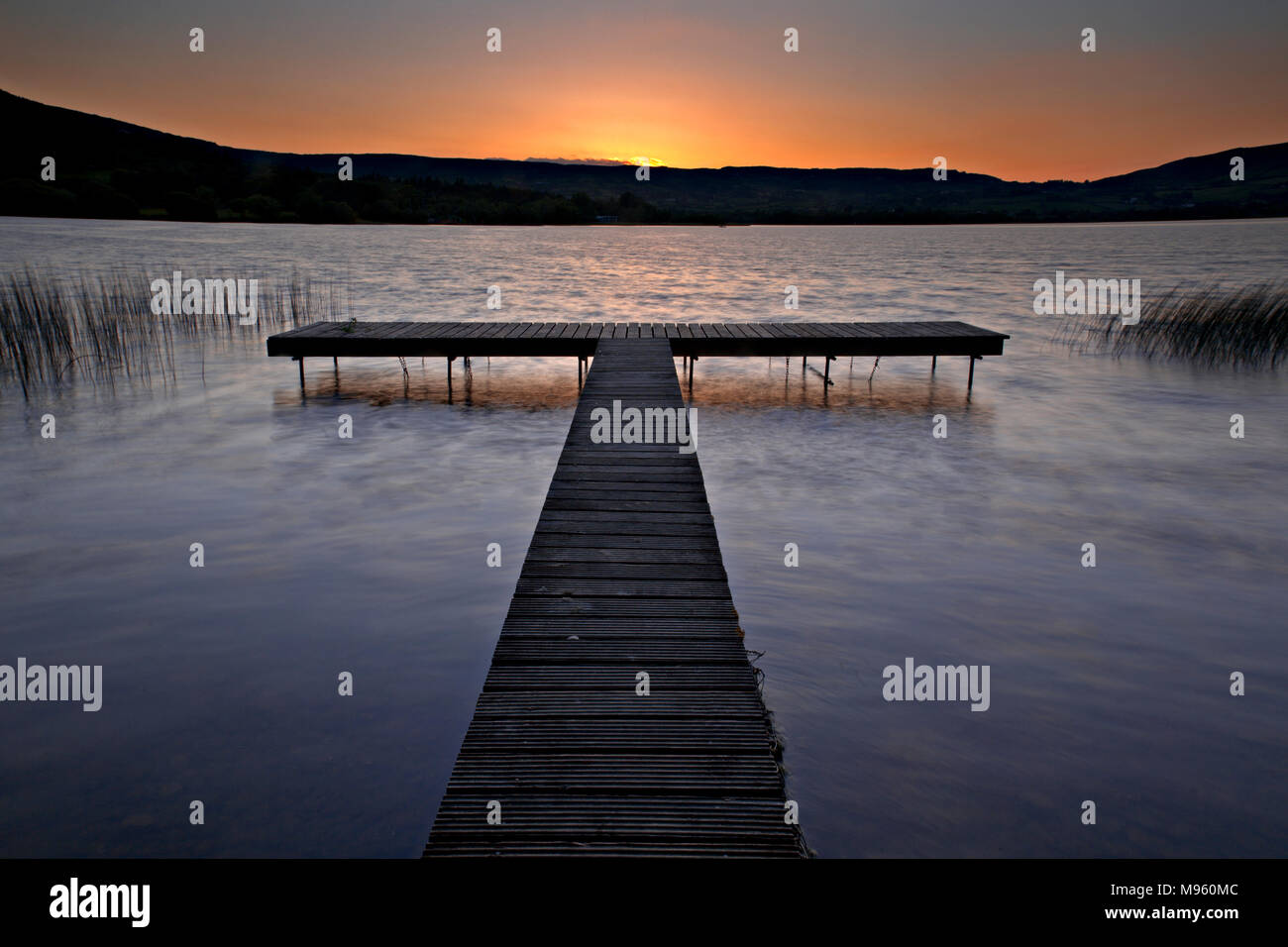 Wooden jetty on the shore of Lough Derg, County Clare, Ireland at sunset Stock Photo