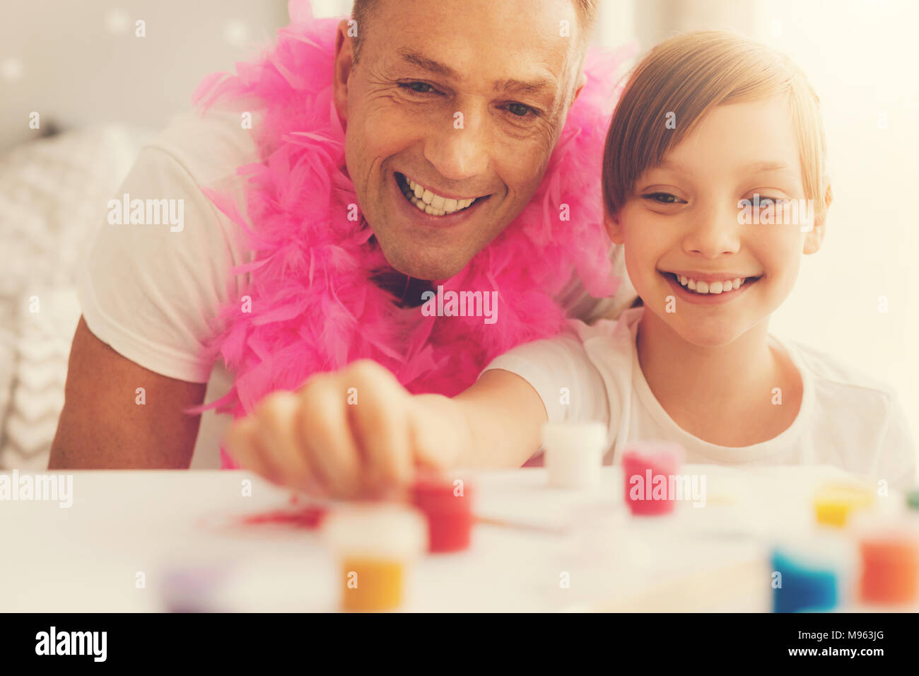Happy delighted man painting together with his daughter Stock Photo
