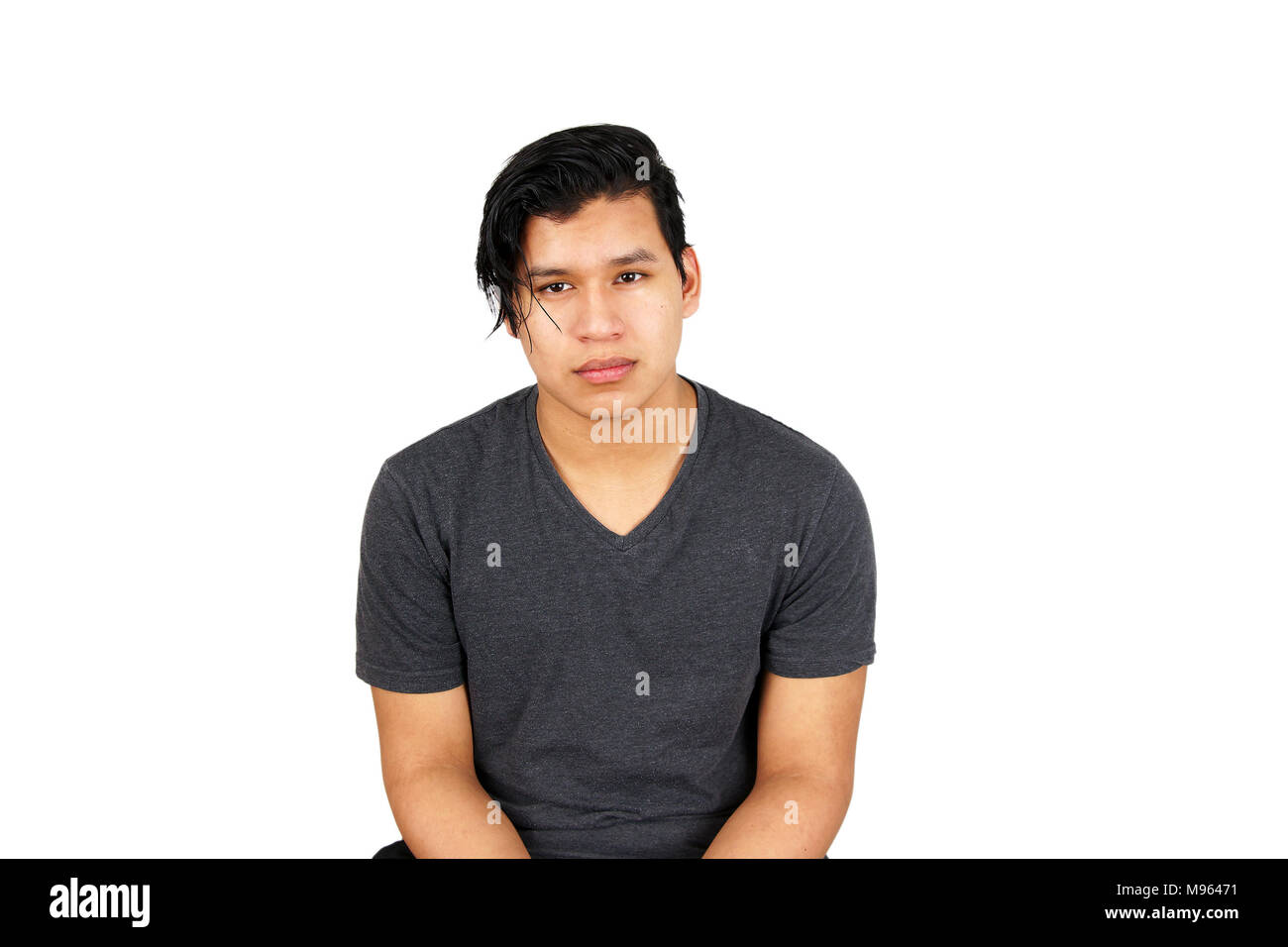 Serious young hispanic teen looking at camera, isolated on white Stock Photo