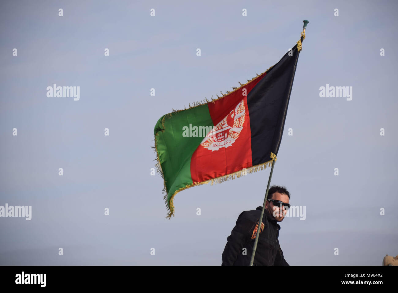 Afghan Commando beneath an Afghan national flag in Shindand Military Base, Herat province. Afghanistan’s elite military forces – the Commandos and the Special Forces are one of the key elements in the Afghan and U.S. strategy to turn the grinding fight against the Taliban and other insurgents around. These pictures show the Commandos and Special Forces during training and in the field; also right before and after an operation in the restive western Afghan province of Farah. Stock Photo