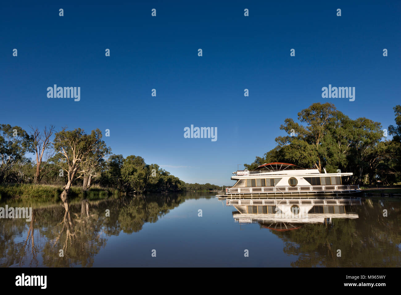 Houseboat moored just upstream from the junction of the Murray and Darling River at Wentworth. The boat is in the Darling River but in the background Stock Photo