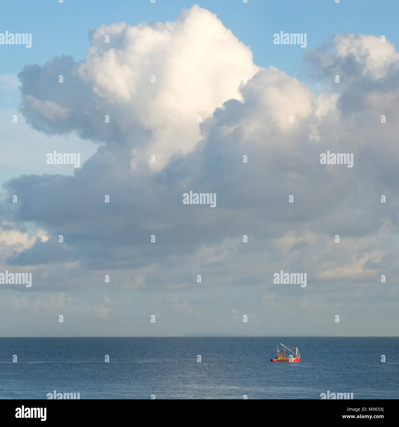 Red fishing boat & large cumulus, Belfast Lough. Stock Photo