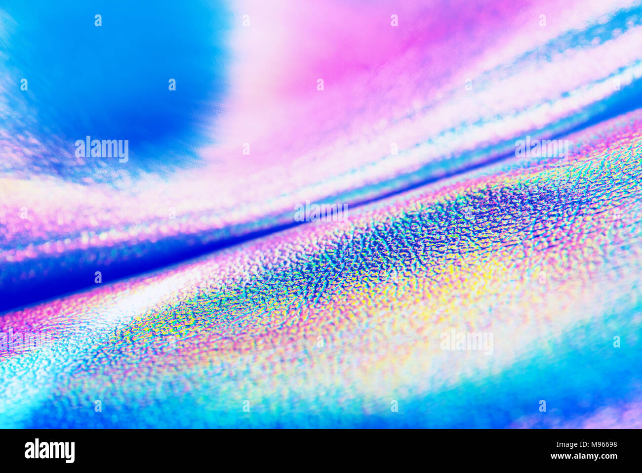 Holographic real texture in green blue pink colors with cracks and creases. Holographic abstract background in neon color design. Stock Photo