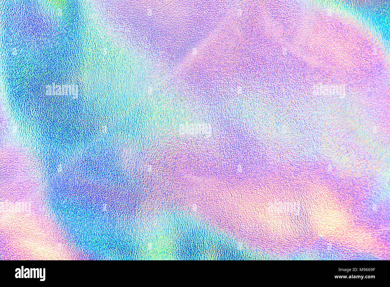 Holographic real texture in blue pink green colors with scratches and irregularities. Holographic color wrinkled foil. Holographic rainbow foil. Stock Photo
