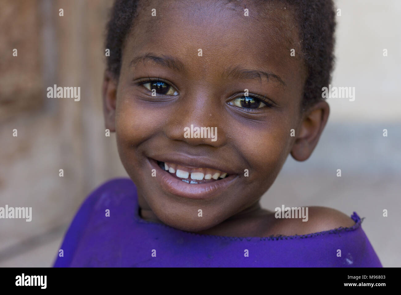 Smiling young girl outside school in rural village of Zanzibar Stock Photo
