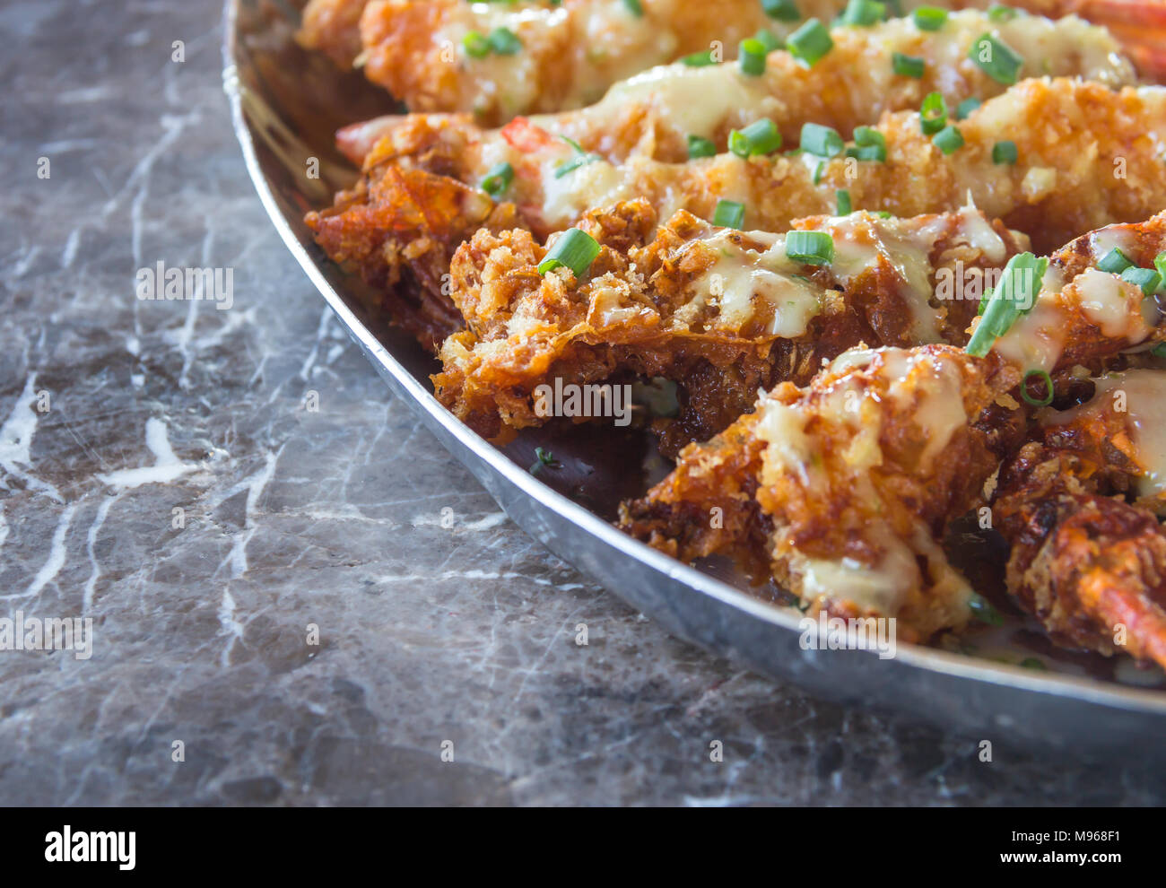 Fried Crispy Shrimp with Onion and mayonnaise Sauce on Top in Stainless Bowl on The Marble Table Stock Photo