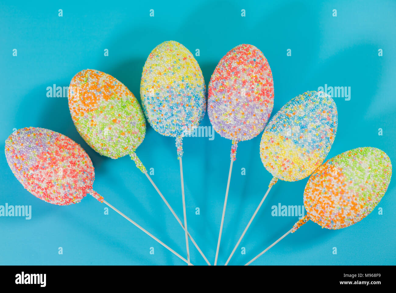 multicolor decorated easter eggs in line on colorful background Stock Photo