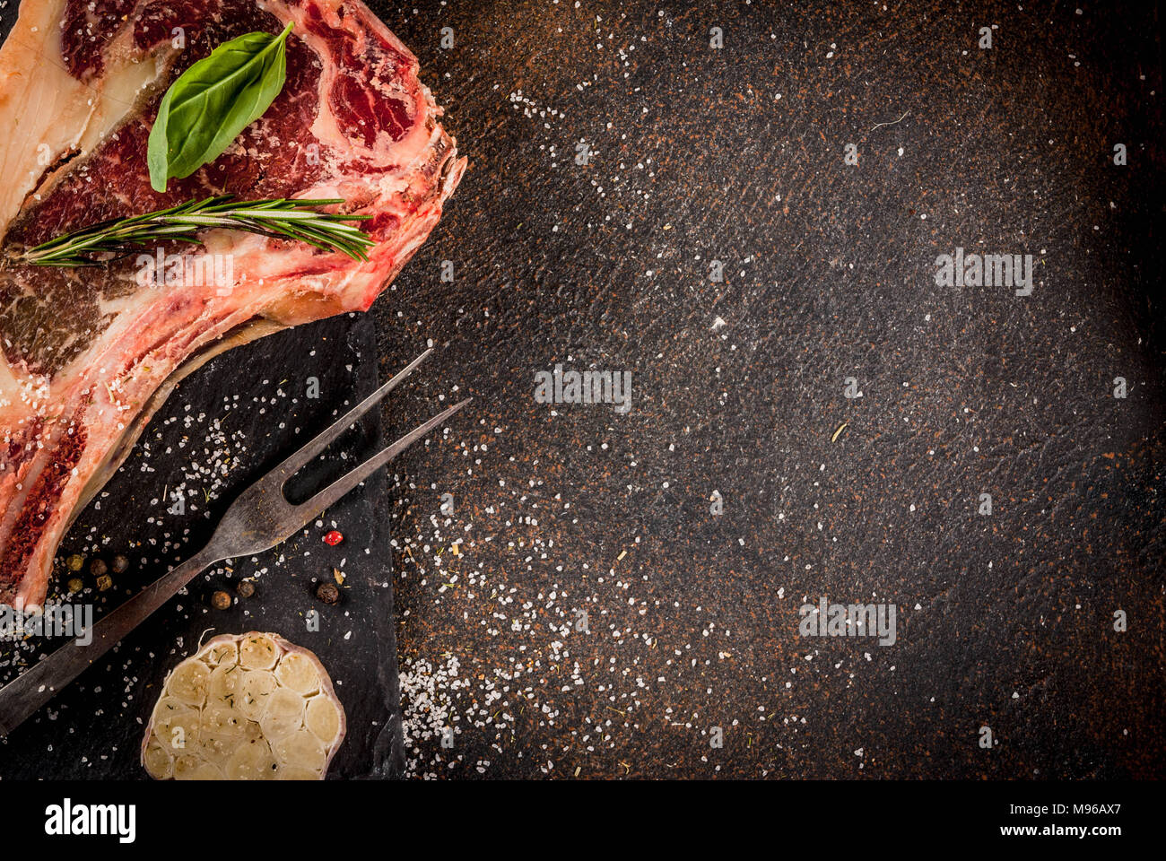Raw beef marbled meat striplon rib eye steak with spices, herbs, dark ...