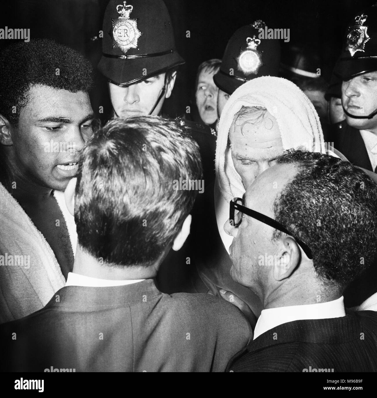 World heavyweight title fight between American champion Cassius Clay and British challenger Henry Cooper at Highbury Stadium, North London. Clay won in the sixth round when the referee had to stop the fight due to a deep gash opening above Cooper's left eye. (Picture) Ali (left) and Cooper (right) after the fight 21st May 1966. Stock Photo