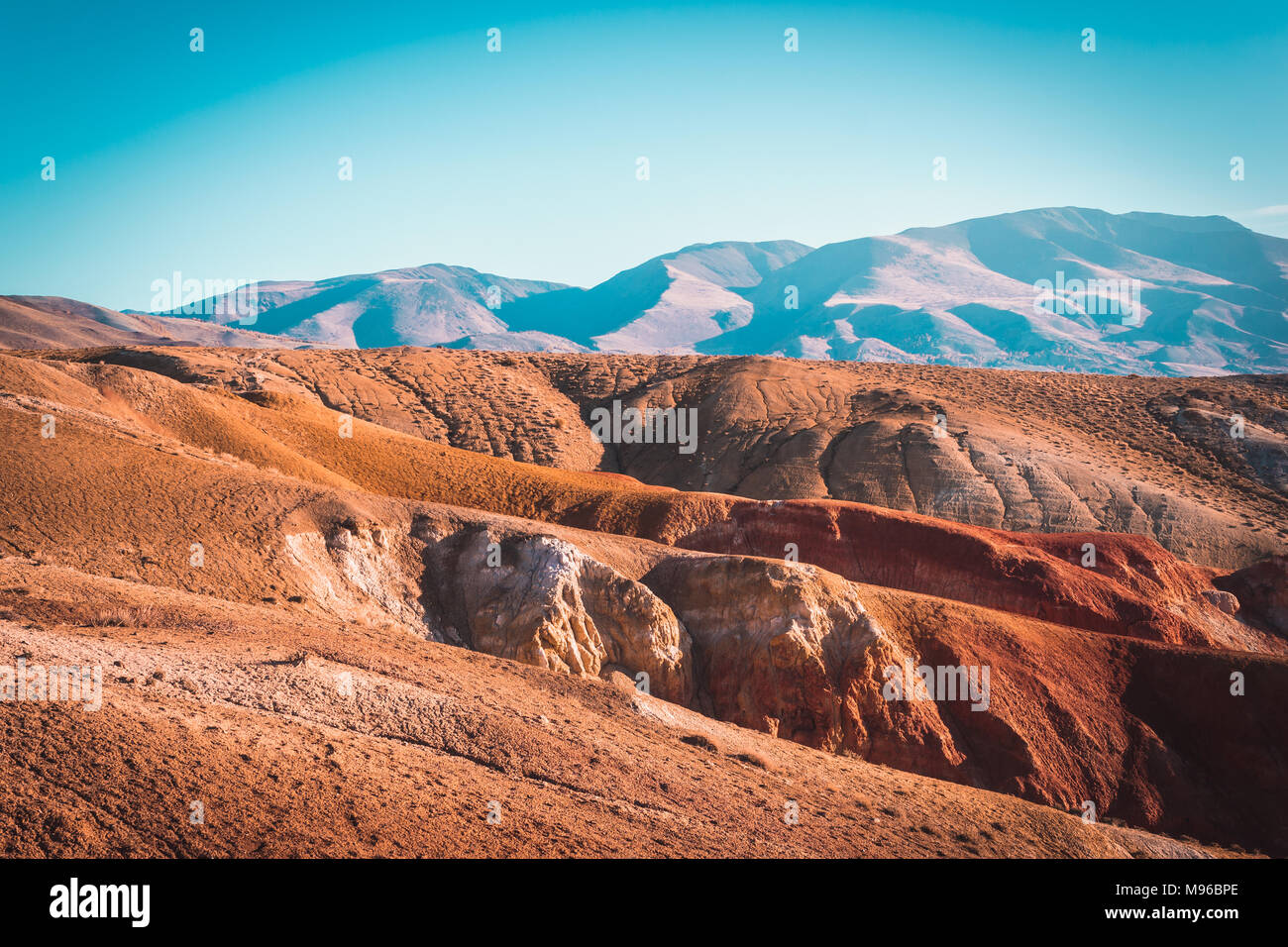 Colored mountains under the blue sky. Red hills of Kyzyl-Chin, Altai. Martian landscape. Red canyon. Stock Photo