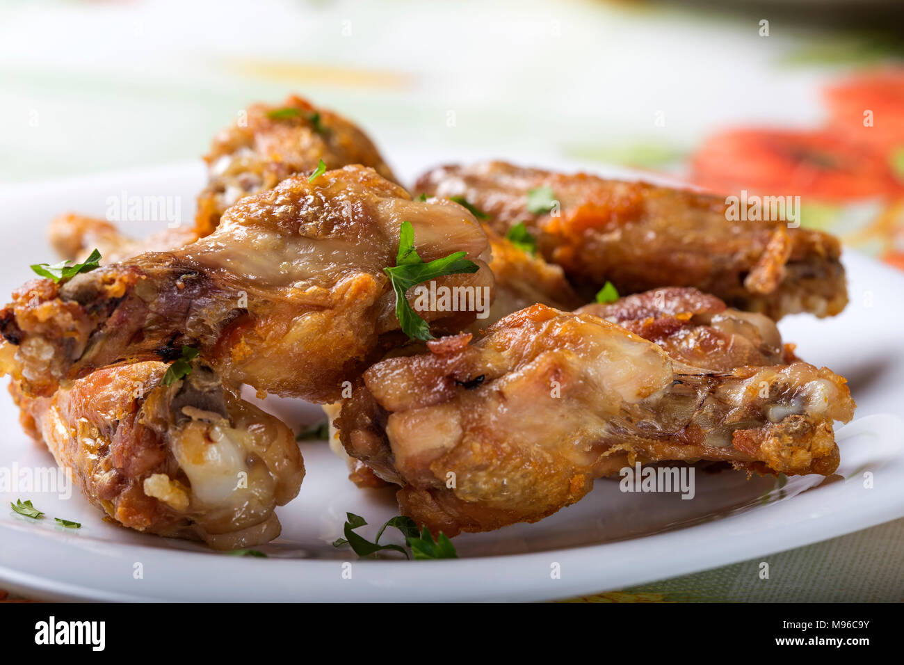 Close up of fresh Grilled chicken drumsticks with parsley leaves on white plate Stock Photo