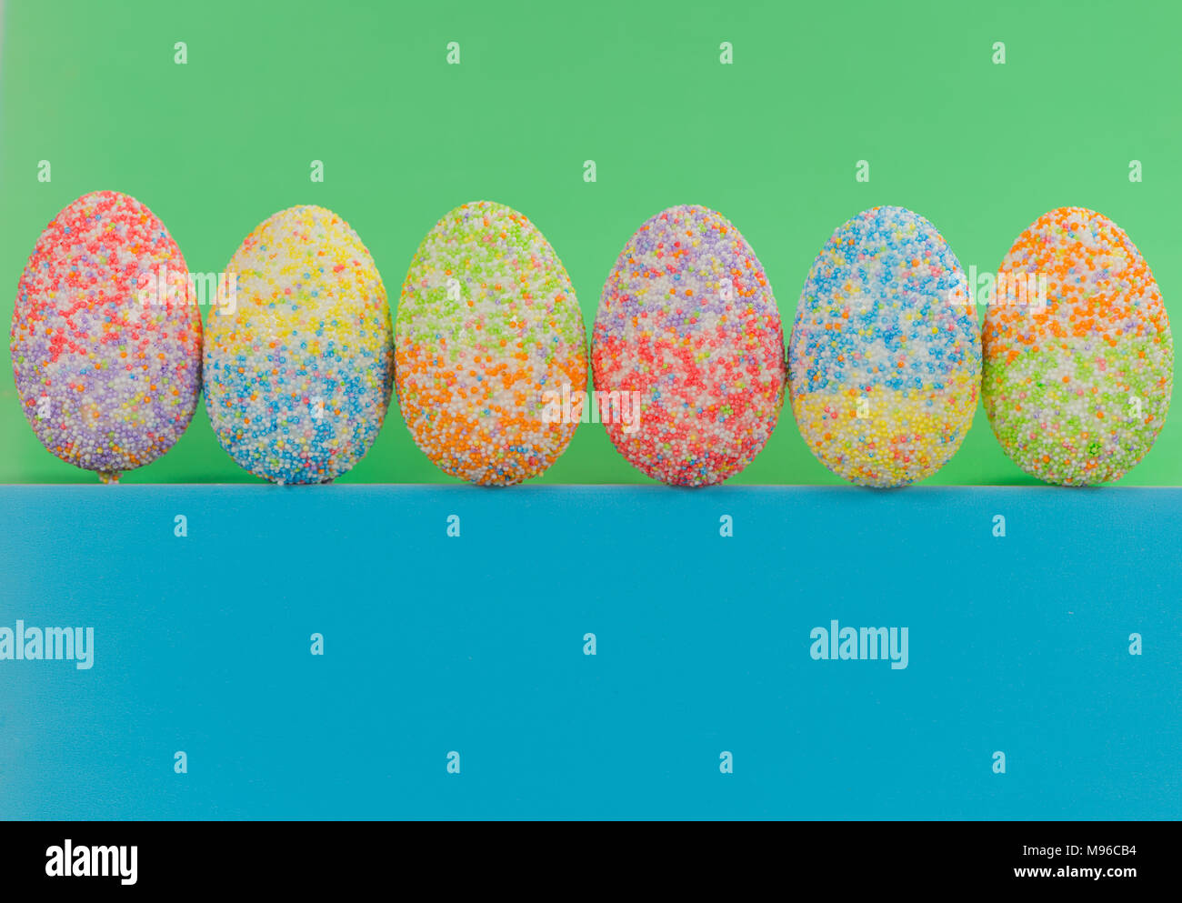 multicolor decorated easter eggs in line on colorful background Stock Photo