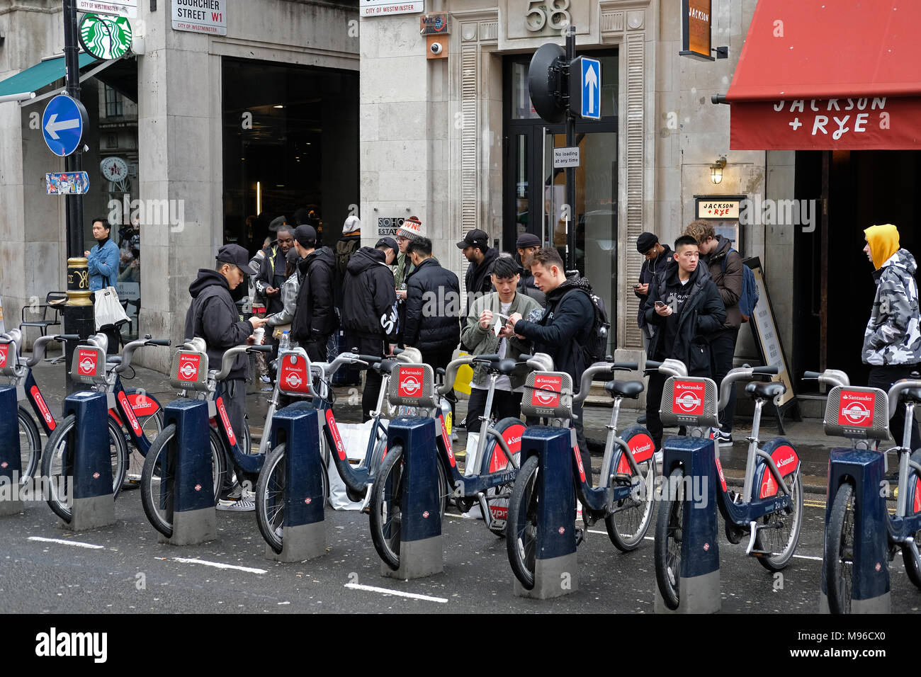Tourists in front of Boris bikes in London. Stock Photo