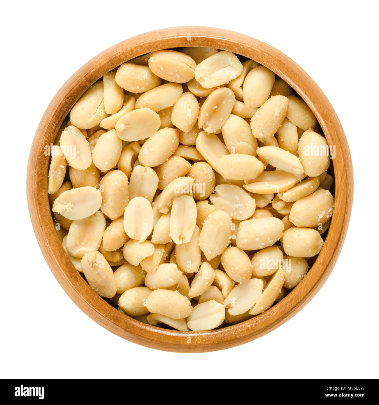 Peanuts, roasted and salted, in wooden bowl. Shelled Arachis hypogaea, also called groundnut and goober, used as a snack. Stock Photo