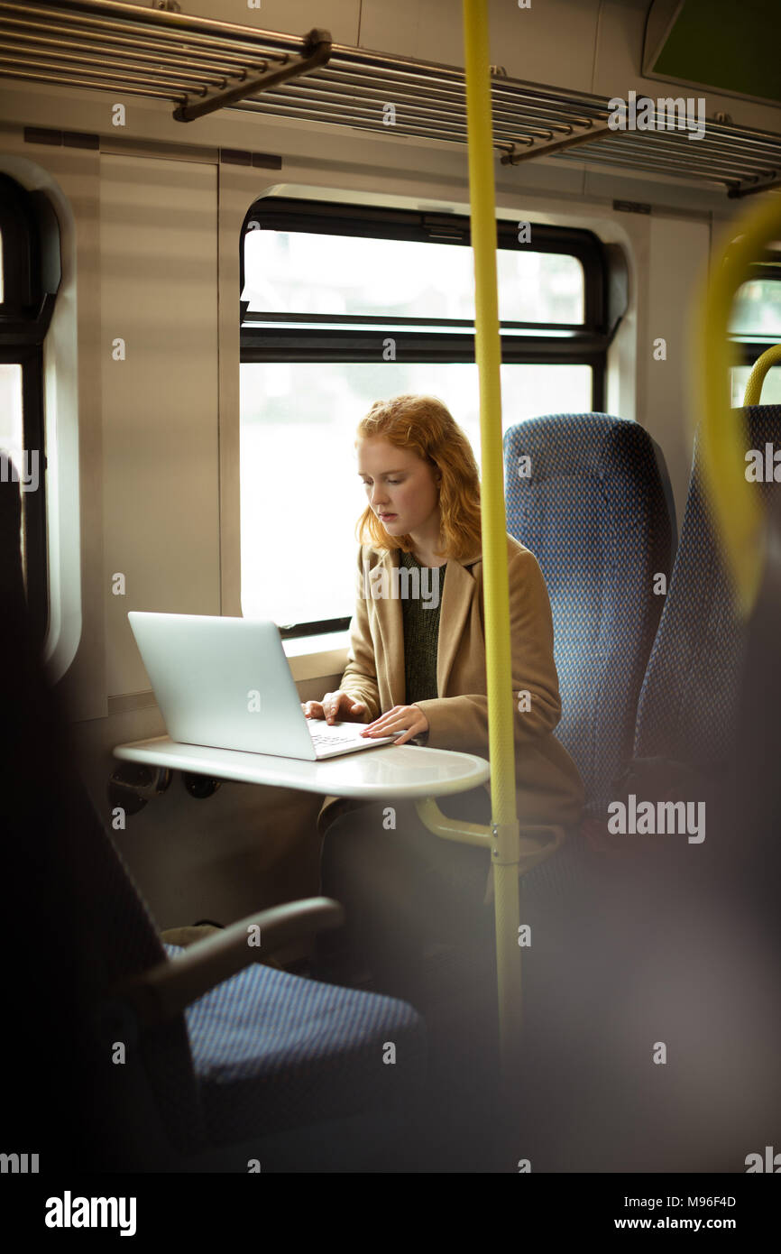 Red hair young woman using her laptop Stock Photo