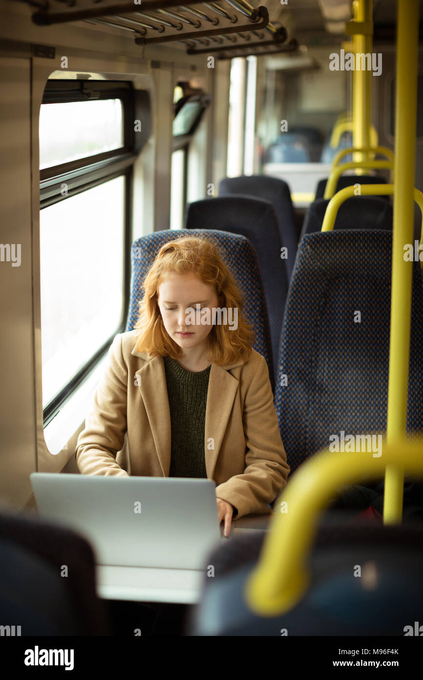 Red hair young woman using her laptop Stock Photo