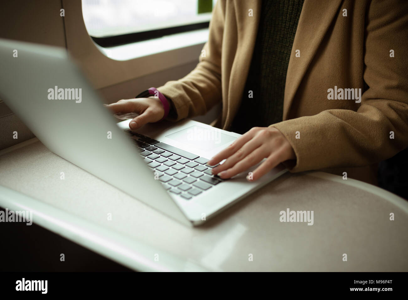 Red hair young woman using her laptop in train Stock Photo