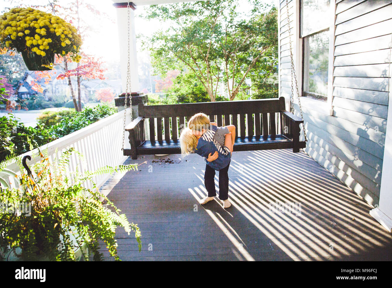 Children hugging on porch Stock Photo