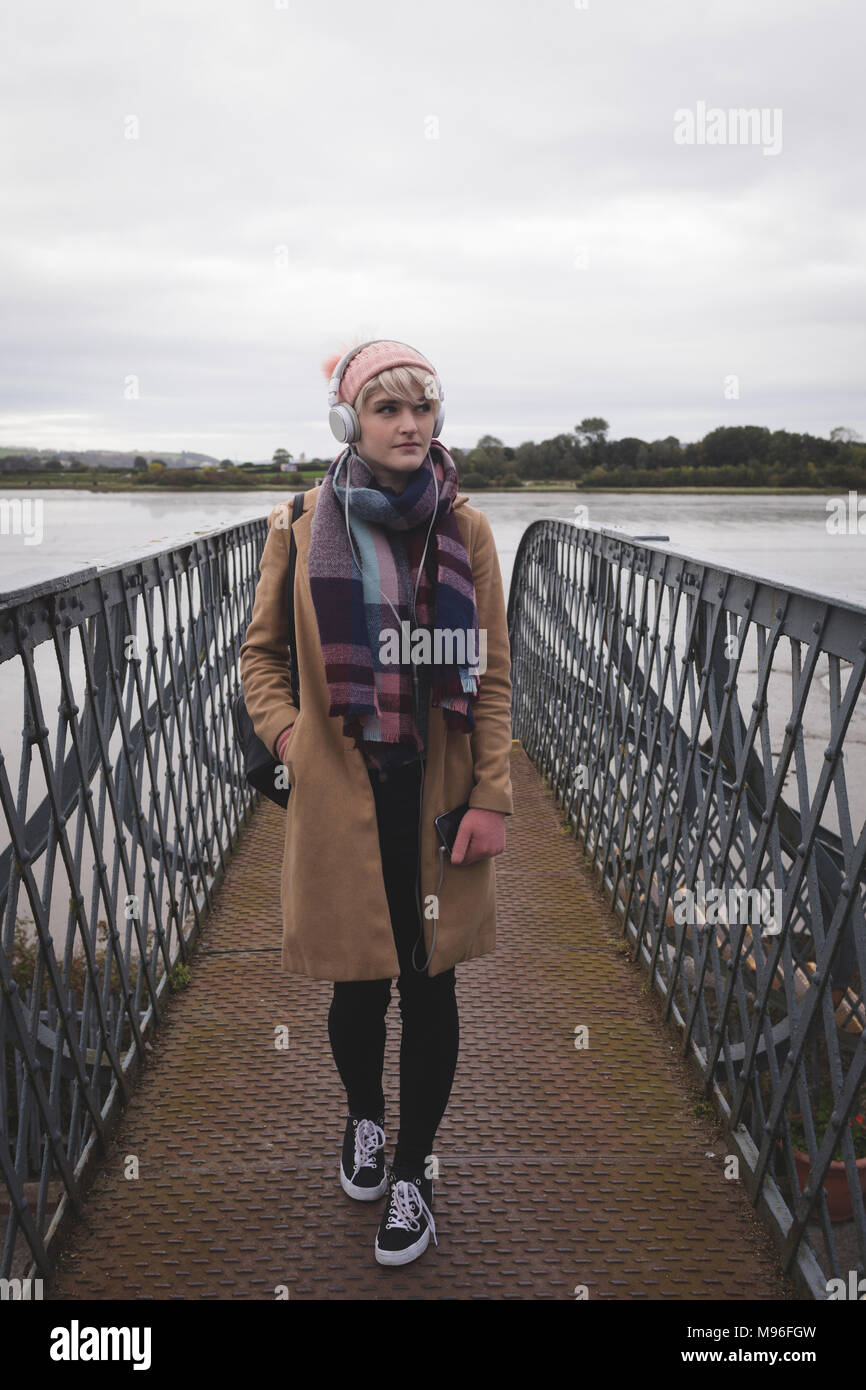 Woman in warm clothing standing on bridge Stock Photo
