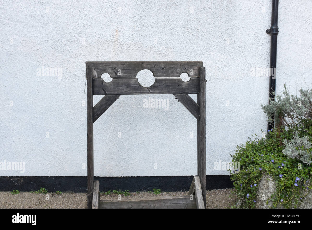 Old wooden stocks in the courtyard of St Lawrence Chapel in Ashburton, Devon which was previously a chantry chapel and is now a community centre Stock Photo