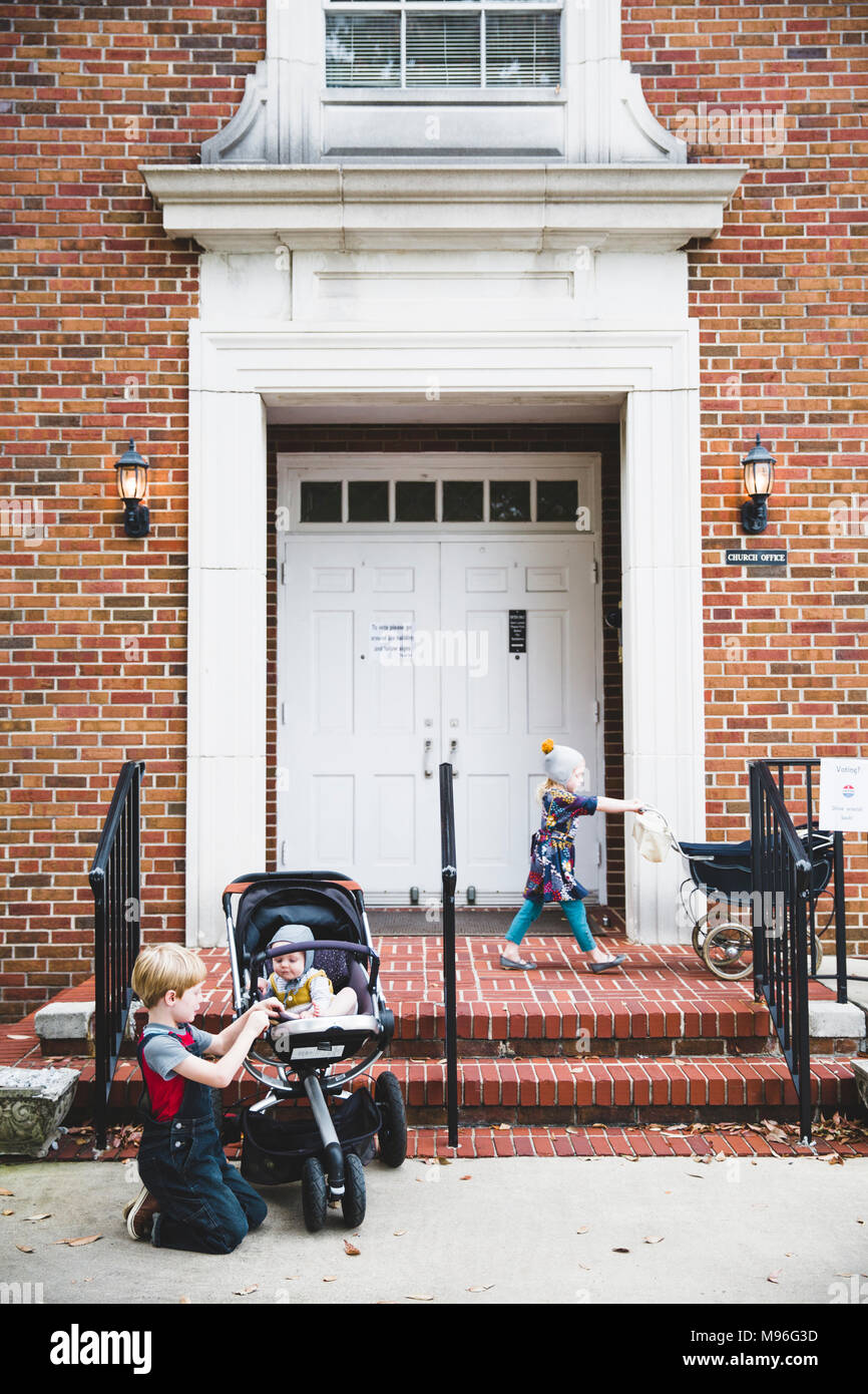 Children with prams outside building Stock Photo