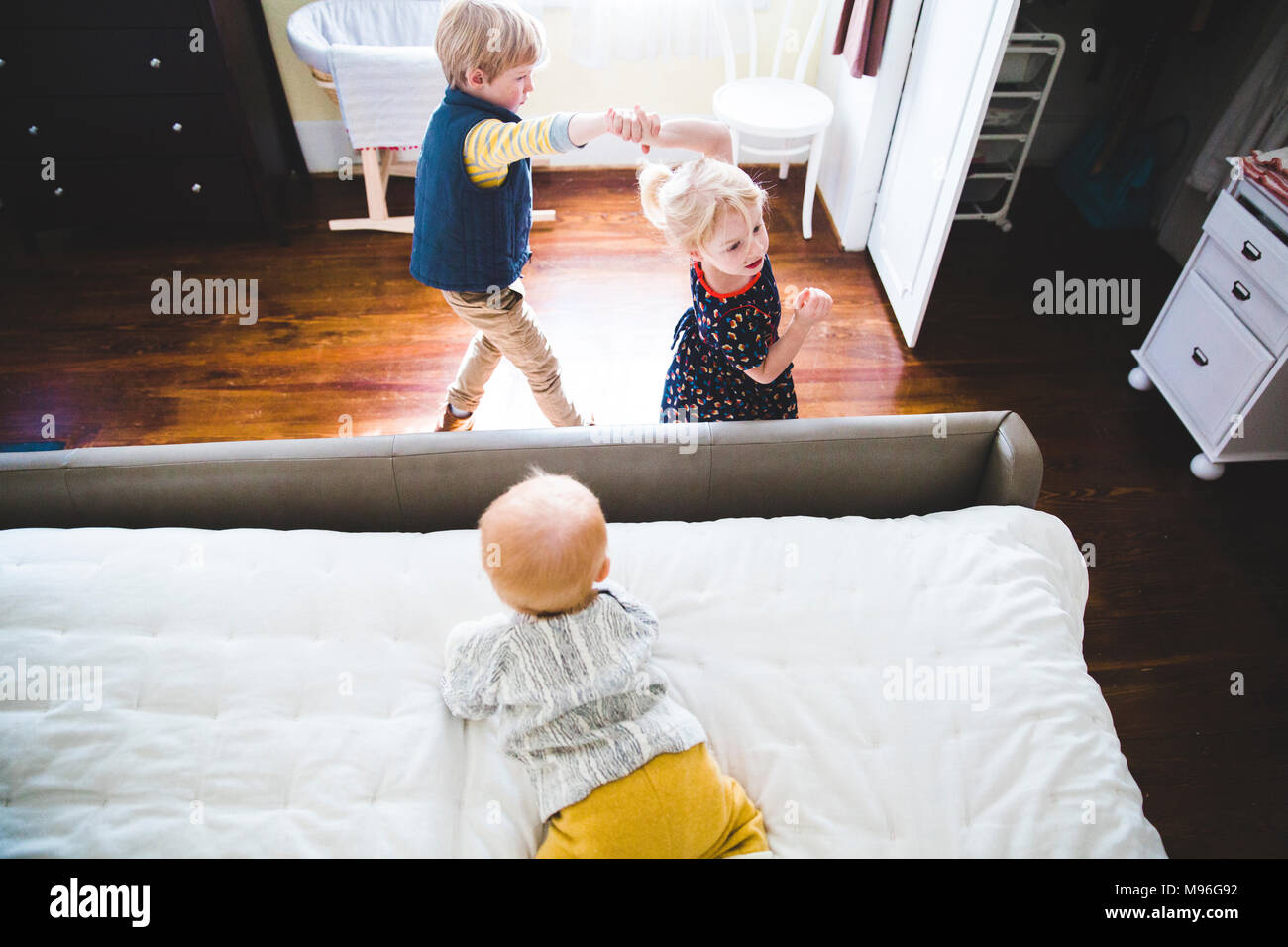 Children playing around bed Stock Photo