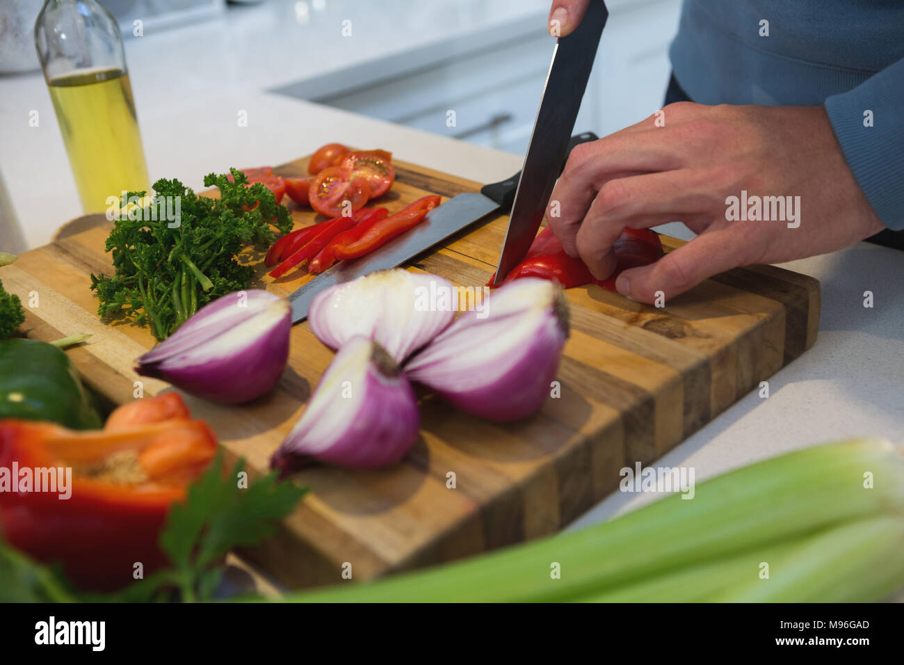 Man cutting vegetables in kitchen at home Stock Photo
