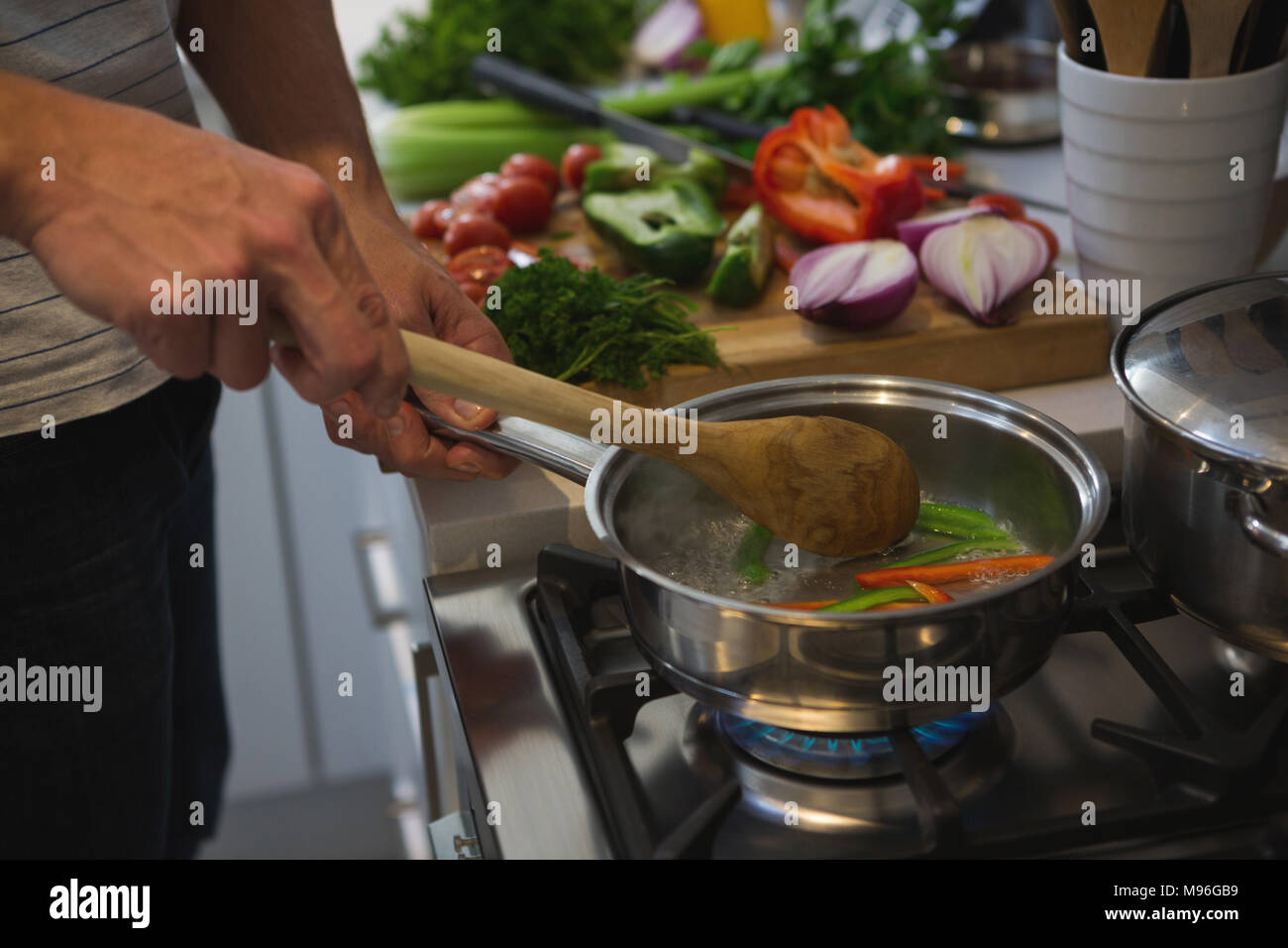 Man cooking food in kitchen Stock Photo